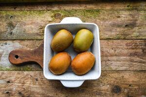 kiwi in a white ceramic bowl on a wooden background on a kitchen board photo