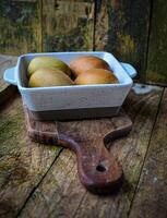 kiwi in a white ceramic bowl on a wooden background on a kitchen board photo