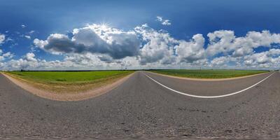 spherical 360 hdri panorama on old asphalt road with clouds and sun on blue sky in equirectangular seamless projection, as skydome replacement in drone panoramas, game development photo