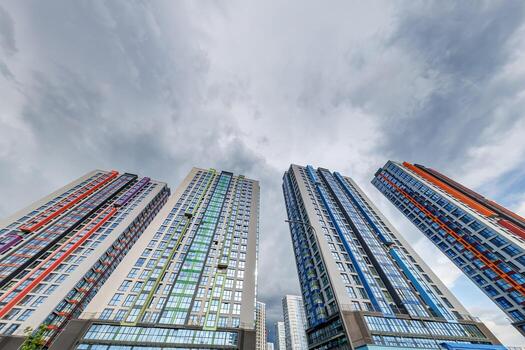 ver desde abajo dentro tormenta cielo con oscuro nubes de grande moderno rascacielos residencial complejo foto