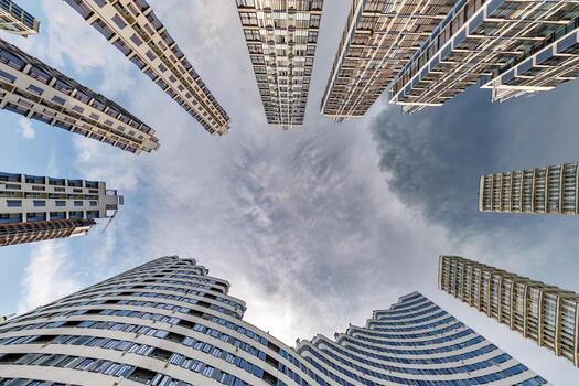 ver desde abajo dentro tormenta cielo con oscuro nubes de grande moderno rascacielos residencial complejo foto