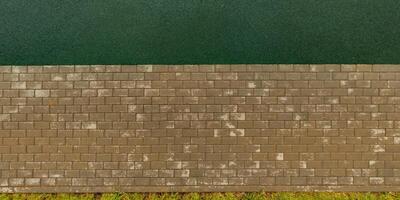 top view of the surface of wet paving slabs and pedestrian footpath after rain photo