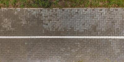 top view of the surface of wet paving slabs and pedestrian footpath after rain photo