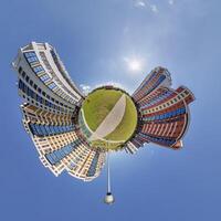 abstract swirling tiny planet spherical panorama of multi-storey buildings of skyscrapers of a residential complex in the form of a butterfly, bugs, crabs in blue sky photo