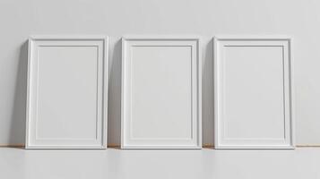Front view of three white minimalistic picture frames on a light background. photo