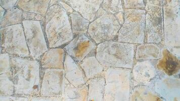 The texture of a road made from rough-textured rock has different shape variants and is dominated by cream and white colors, very suitable for background and texture design photo
