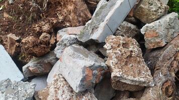 a pile of destroyed building blocks, placed somewhere. You can clearly see the damaged bricks on the building walls and foundation photo