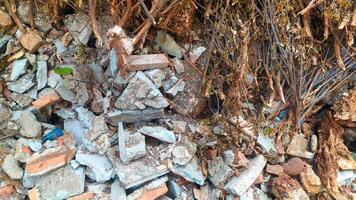 a pile of destroyed building blocks, placed somewhere. You can clearly see the damaged bricks on the building walls and foundation photo