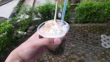 Indonesian drink called es cincau, made from grass jelly with coconut milk sauce, topped with liquid sugar, and added with ice to make it colder. photo