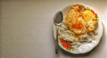 A simple morning dish of hot white rice with fried duck eggs photo