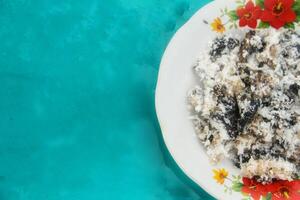 Gatot food with grated coconut topping, Gatot is a typical Indonesian food made from cassava which is dried for some time to produce a distinctive black color photo