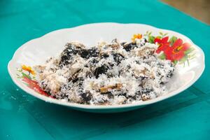Gatot food with grated coconut topping, Gatot is a typical Indonesian food made from cassava which is dried for some time to produce a distinctive black color photo