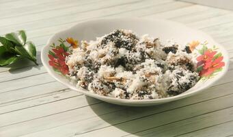 Gatot food with grated coconut topping, Gatot is a typical Indonesian food made from cassava which is dried for some time to produce a distinctive black color photo