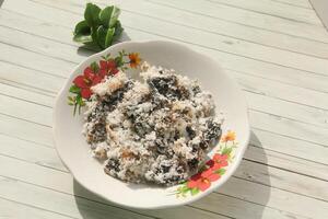 Gatot food with grated coconut topping, Gatot is a typical Indonesian food made from cassava which is dried for some time to produce a distinctive black color photo