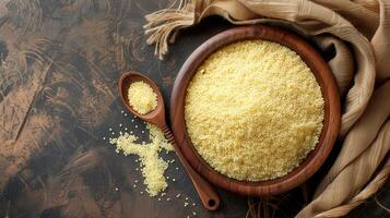 Raw Couscous in Wooden Bowl and Spoon photo