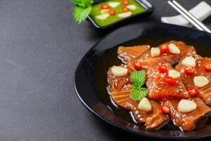 Pickled Salmon with Soy Sauce with chilli and garlic on stone background, photo