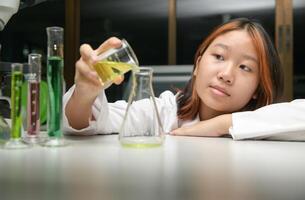 Education concept. Little scientists children is pouring the solution into erlenmeyer flask photo