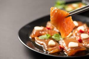 Pickled Salmon with Soy Sauce with chilli and garlic on stone background, photo
