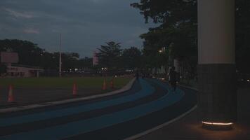 Evening walk on a dimly lit running track video