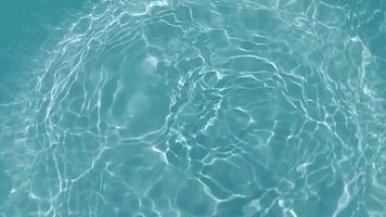 Blue water with ripples on the surface. Defocus blurred transparent blue colored clear calm water surface texture with splashes and bubbles. Water waves with shining pattern texture background. video