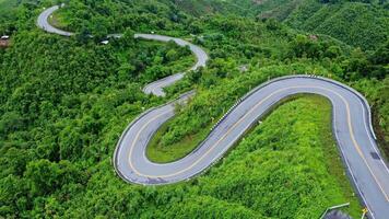 Aerial view of a road in the middle of a forest, construction of a curved road up the mountains in northern Thailand. video