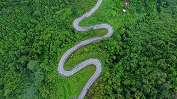 Aerial view of a road in the middle of a forest, construction of a curved road up the mountains in northern Thailand. video