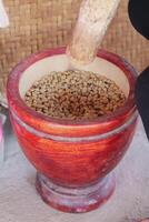 Farmers use wooden mortars and pestles to break the husks apart from the coffee beans to remove unwanted husks from coffee beans before processing them to produce high quality coffee beans for export. photo