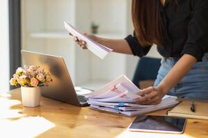 A pile of documents that the secretary has prepared for meetings of the company board of directors and investors. Many documents were arranged and prepared in piles on the desk in the secretary office photo