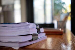 pile of documents sat on desk in office was pile of documents that had been prepared to be presented at meeting as summary of annual operations. Documents prepared for storage and piled on the desk. photo