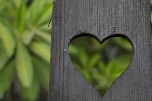 background is a heart-shaped piece of wood, which means I love you and is also a symbol of love and friendship for one another. A heart-shaped stencil on the background was used to decorate the venue. photo