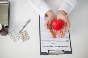 The red heart symbol in the doctor's hand is a symbol of the campaign to care for the health of heart disease patients and encourage people at risk of heart disease to come for regular check-ups. photo