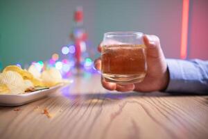 businessman sits and holds glass of liquor in his hand to drink relieve stress after experiencing problems in business. businessman drinking alcohol relieve stress from failed business venture. photo