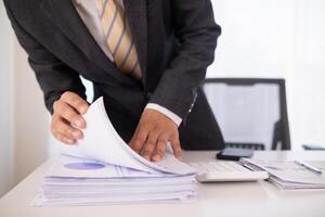 A pile of documents that the secretary has prepared for meetings of the company board of directors and investors. Many documents were arranged and prepared in piles on the desk in the secretary office photo