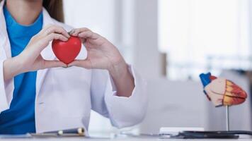 The red heart symbol in the doctor's hand is a symbol of the campaign to care for the health of heart disease patients and encourage people at risk of heart disease to come for regular check-ups. photo