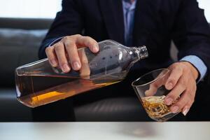 businessman sits alone in his office drinking brandy after discussing and agreeing with investors to do business in meeting until reaching satisfactory conclusion. concept of relaxing with brandy photo