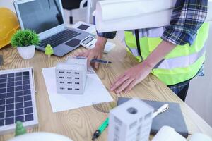 Engineers are reviewing plans from architects to prepare to install solar panels and wind turbines on the building to efficiently produce electricity using the concept of green energy from solar cells photo