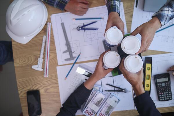 Businessmen and investors well teams of architects and engineers clinked cup coffee to congratulate them on successful agreement. team celebration idea after successfully concluding business contract.