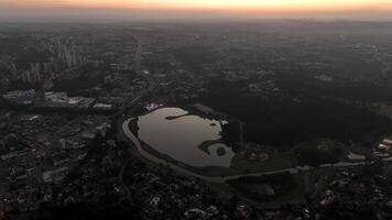 Curitiba in Parana, Brazil. Aerial View. Wonderful sunset with views of buildings and Tangua Park. Lake with reflection. video