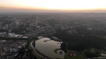 Curitiba in Parana, Brazil. Aerial View. Wonderful sunset with views of buildings and Tangua Park. Lake with reflection. video