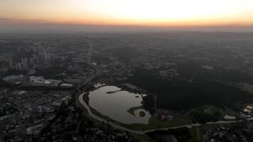 Curitiba in Parana, Brazil. Aerial View. Wonderful sunset with views of buildings and Tangua Park. Lake with reflection. video