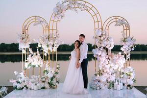 bride and groom against the backdrop of a yellow sunset photo