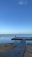 Couple Walking on Floating Dock at Beach photo