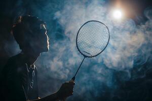 Picture of a man playing badminton with smoke photo