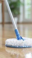 closeup of a floor mop with white yarn and metal stick on tiles floor with blur background photo