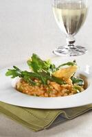 Asparagus risotto with pirarucu fish and fried cassava chips photo