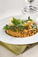 Asparagus risotto with pirarucu fish and fried cassava chips photo