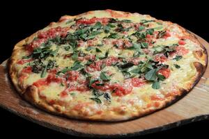 margherita pizza coming out of the oven on wooden paddle photo