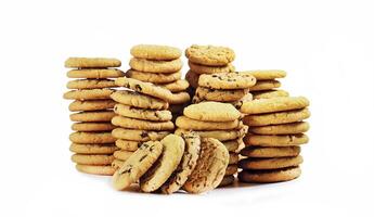 stacks of vanilla cookies with chocolate chips on white background photo