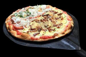 Brazilian pizza with each half with different flavors and toppings coming out of the oven photo