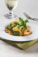 Asparagus risotto with pirarucu fish and fried cassava chips photo